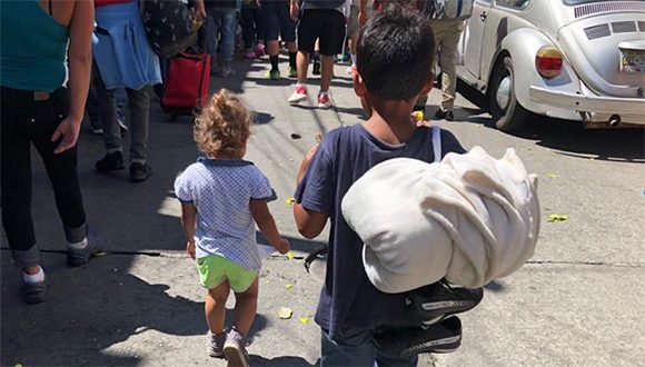 Caravana migrantes nino bulto 580x330